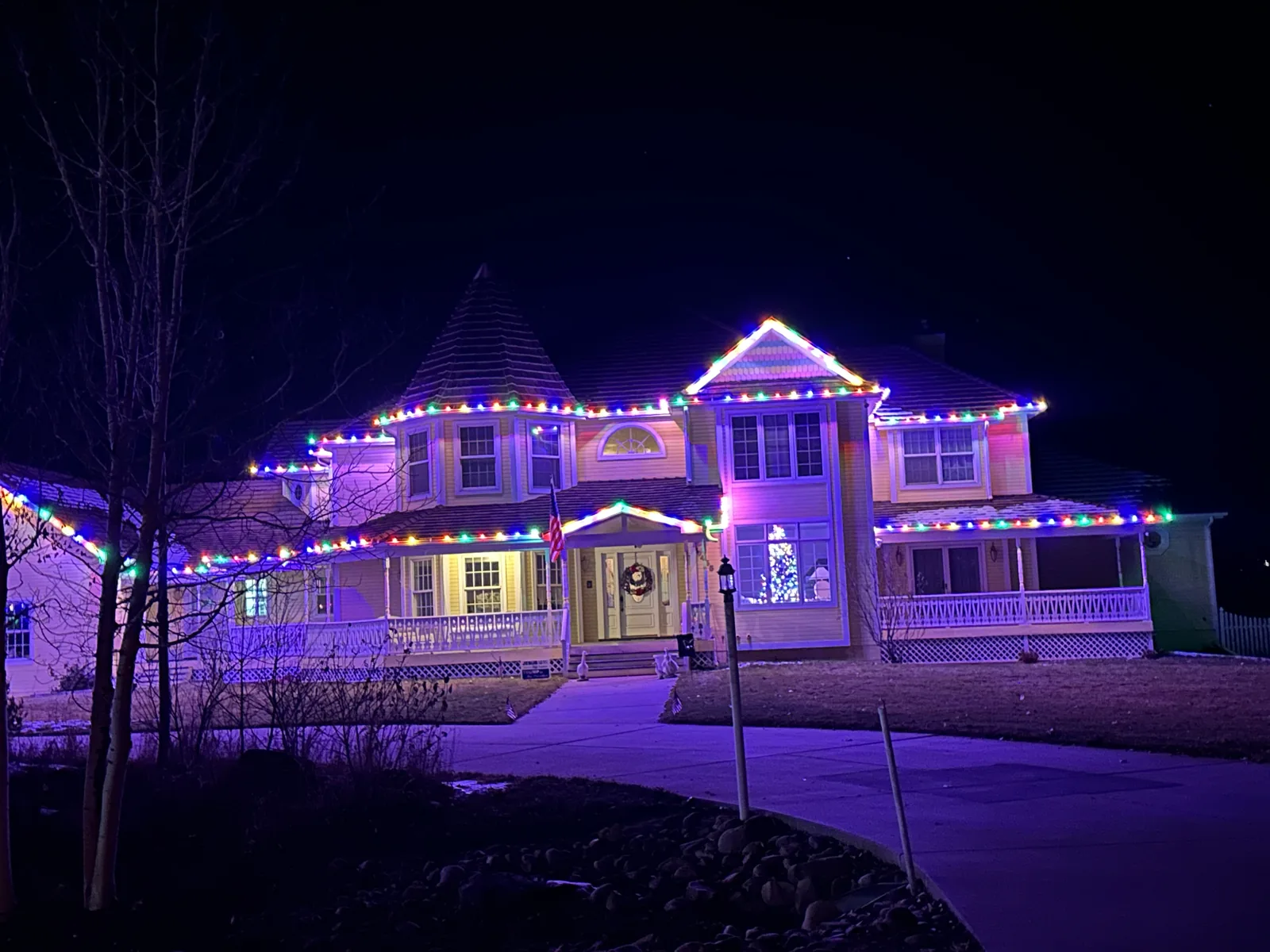 A large Boulder Victorian outlined in multicolour along every roofline, turret and porch