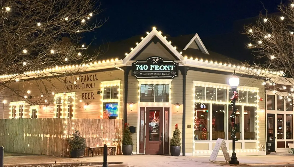 Commercial building frontage outlined in warm white lighting at night