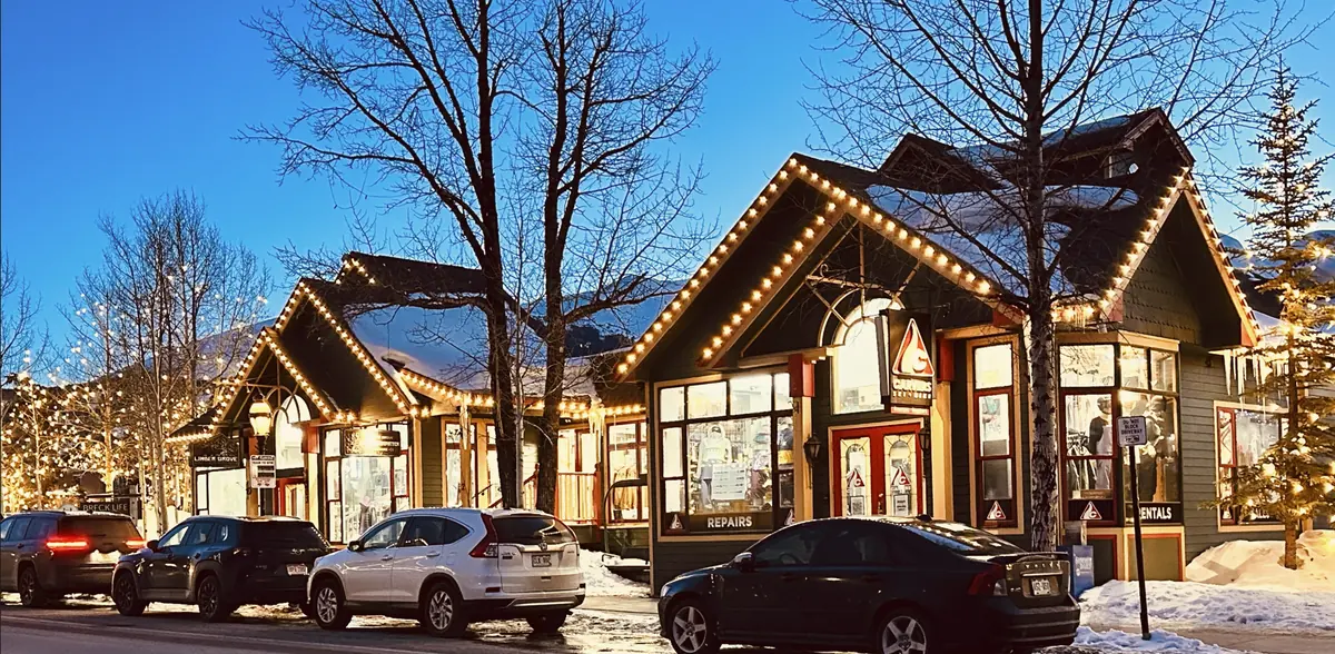 Carvers ski shop in Breckenridge with every gable and eave outlined in warm white bulbs against a blue winter sky