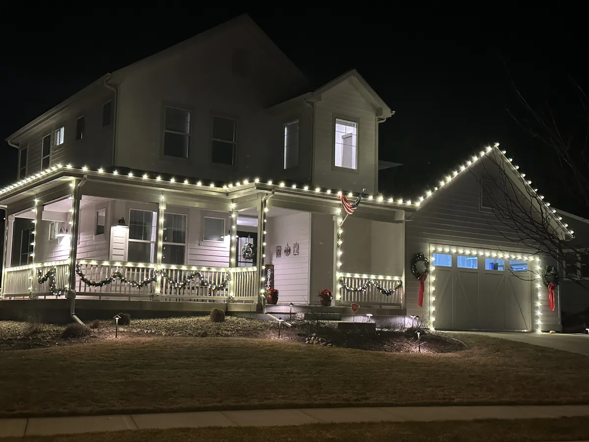 An Erie home outlined in warm white along every gable, the porch rail and the garage