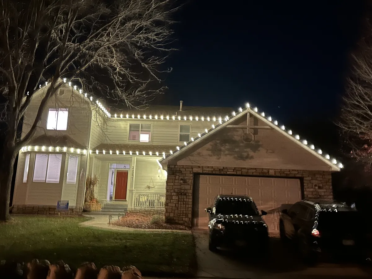 A Longmont home outlined in warm white along every roofline, gable and the garage