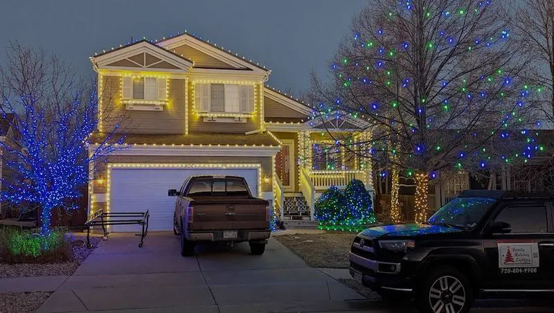 Family Holiday Lighting truck parked at a completed installation at dusk