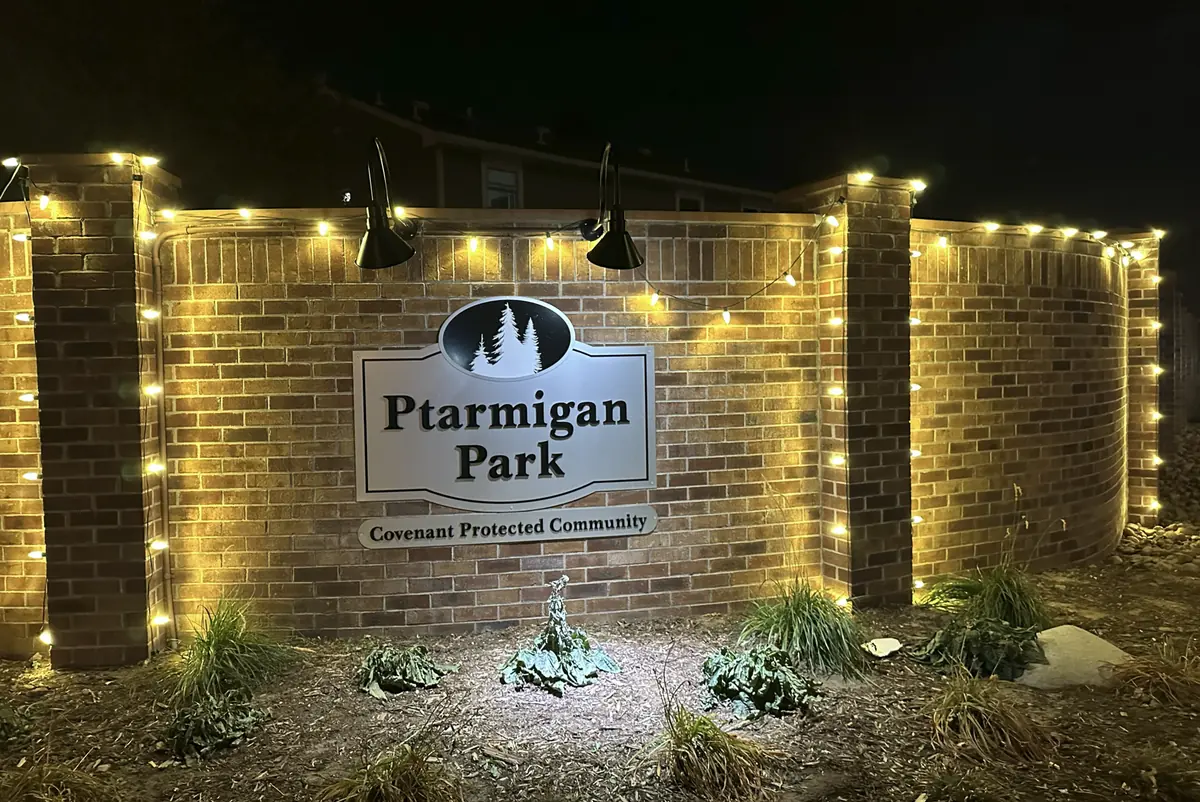 Ptarmigan Park community entrance wall traced in warm white bulbs along every course and pilaster