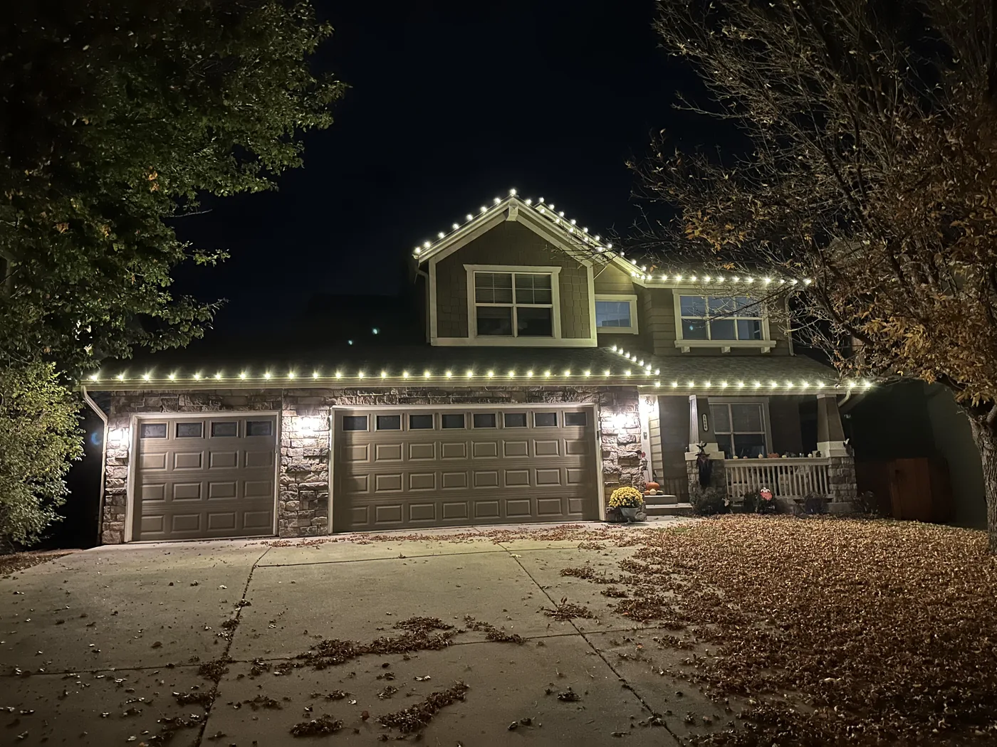 A Longmont two-story home with warm white bulbs along every roofline, gable and garage